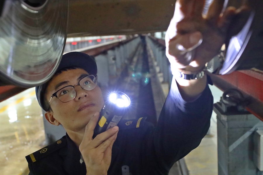 1月16日凌晨，在福州动车段福州南动车所检修库内，动车组工作人员在检查动车车轮走行部件，保证动车安全上线。丁波摄