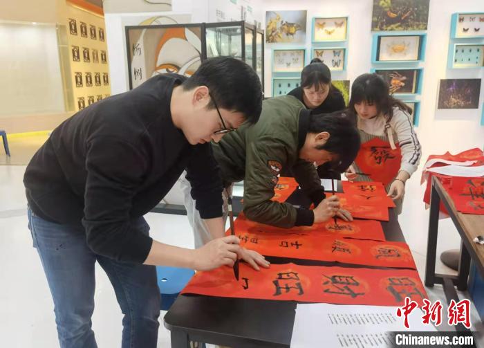 闽台青年正在写春联。　郑江洛 摄