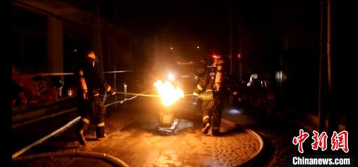 图为消防救援人员从着火屋内搜救出一瓶正在熊熊燃烧的液化气罐,并合力转移至安全地带。 三元区消防救援大队供稿 摄 图为消防救援人员从着火屋内搜救出一瓶正在熊熊燃烧的液化气罐,并合力转移至安全地带。 三元区消防救援大队供稿 摄