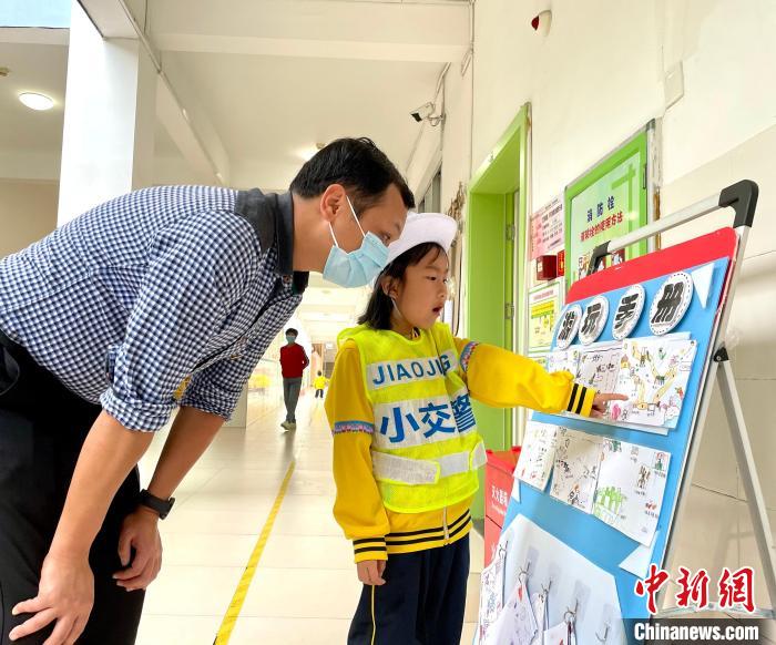 小朋友向活动嘉宾讲解游玩手册。　吕巧琴 摄