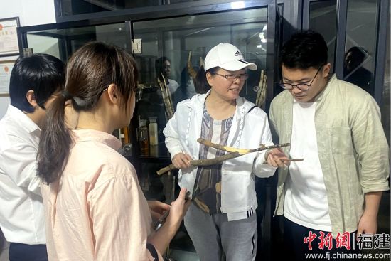  台胞张淑桂（右二）向访客介绍沉香产品。吴冠标 摄