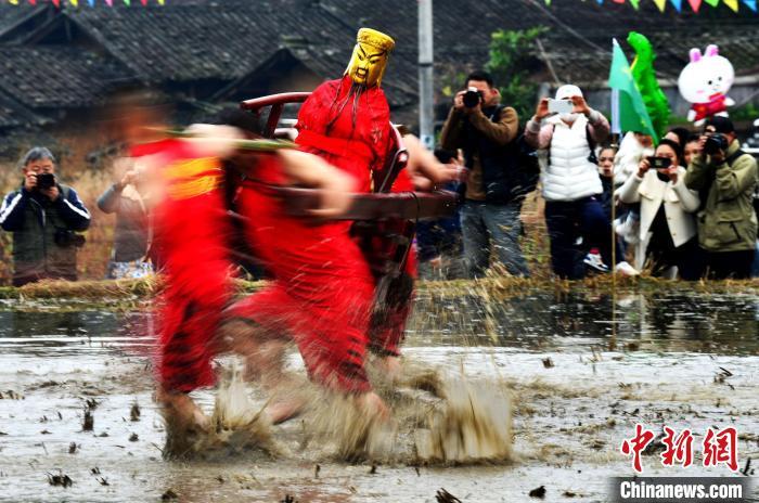 图为村民们抬着上百斤重的关公菩萨在泥田里奔跑、角力，以此来祈愿风调雨顺、五谷丰登。　张斌 摄