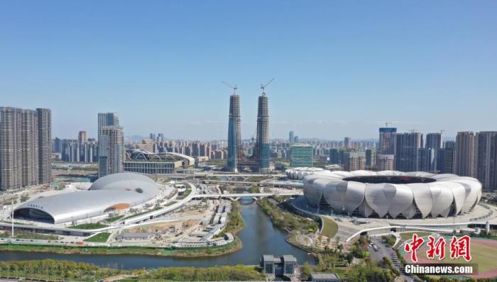 资料图：拍杭州亚运会主体育馆(右)、游泳馆(左)。目前，杭州2022年亚运会主体育馆、游泳馆以及综合训练馆已基本竣工。杭州亚运会期间，“亚运三馆”中的主体育场与游泳馆将承担篮球、游泳、跳水和花样游泳等比赛，综合训练馆则将承担集中训练及医疗、商务等功能。<a target='_blank' href='/'>中新社</a>记者 王刚 摄