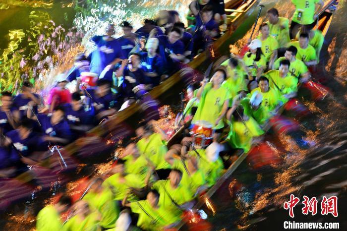 图为6月17日晚，福建长乐江田镇三溪村村民在夜竞龙舟。　张斌 摄