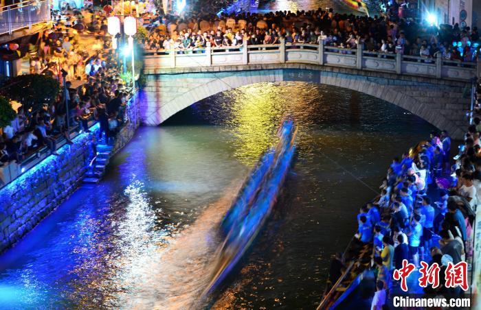 图为6月17日晚，福建长乐江田镇三溪村夜竞龙舟现场人潮如涌，热闹非凡。　张斌 摄