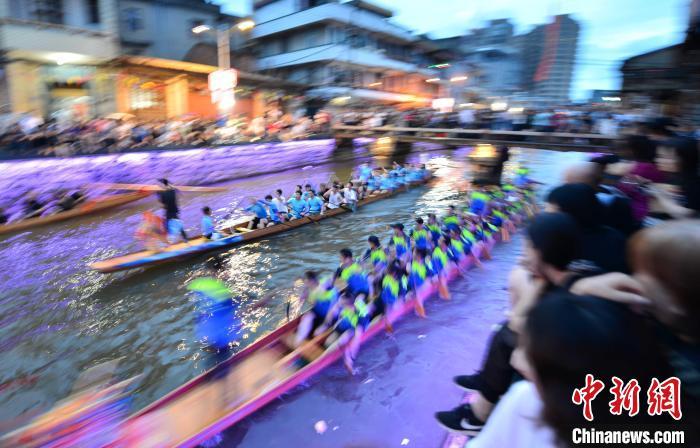 图为6月17日晚，福建长乐江田镇三溪村村民在夜竞龙舟。　张斌 摄