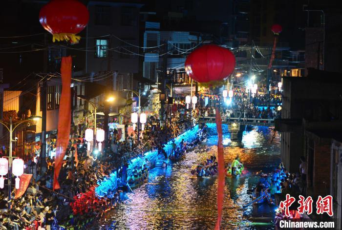 图为6月17日晚，福建长乐江田镇三溪村村民在夜竞龙舟。　张斌 摄