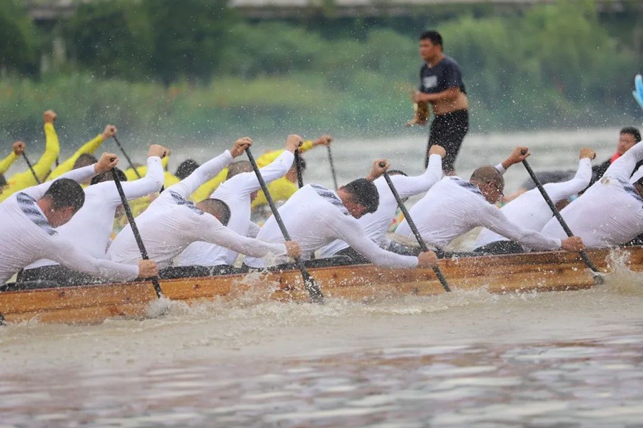 龙舟队员们动作整齐有序，在水面上划起一道道白浪。