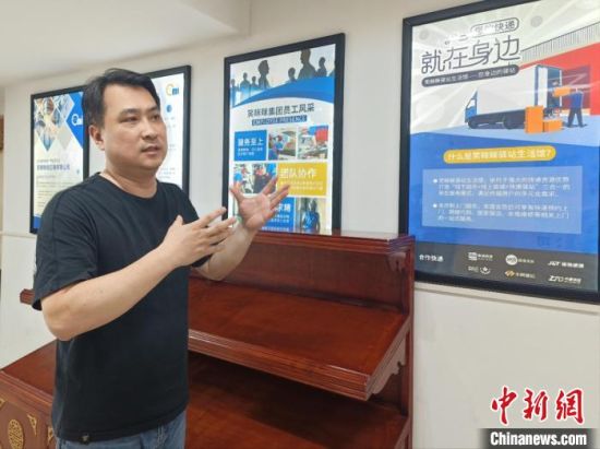图为柳光第介绍所从事的快递业务发展情况。　廖珍妹　摄