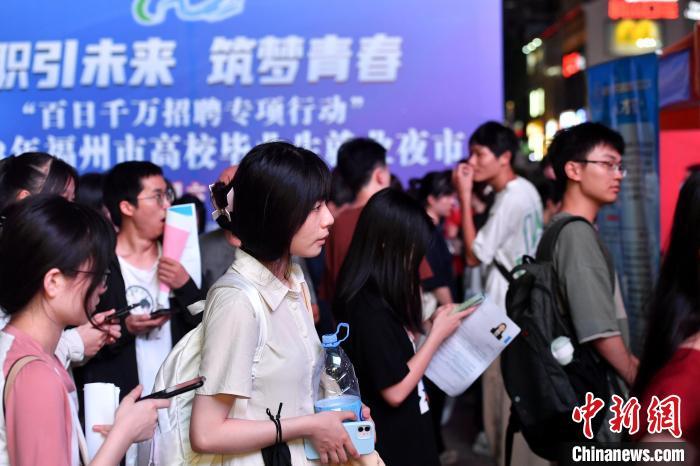 图为应聘者排队面试。 吕明 摄