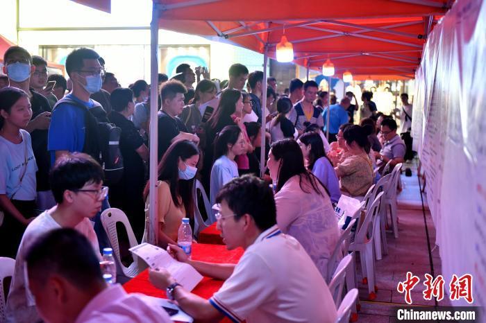 图为应聘者排队面试。 吕明 摄