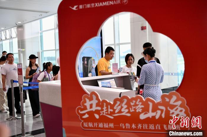 福州-乌鲁木齐往返直飞航班首飞旅客正在排队登机。　王东明 摄