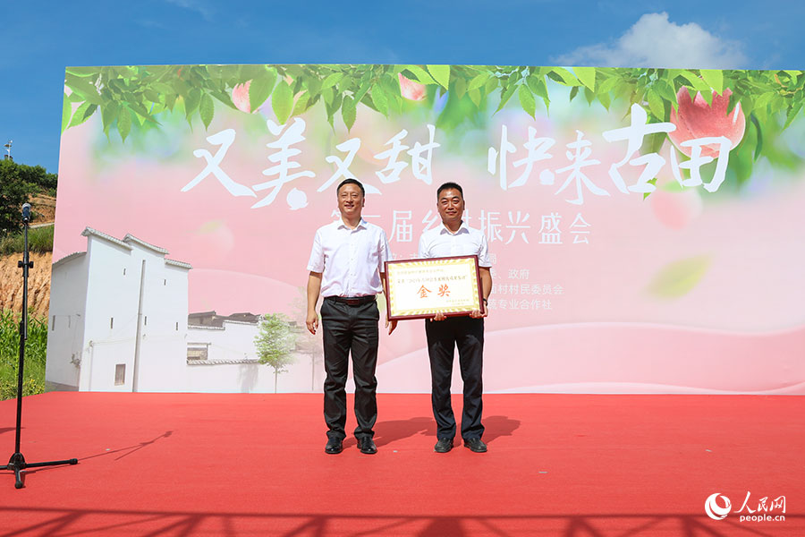 活动现场,与会领导为评选出的古田县水蜜桃优质果获奖得主颁奖。人民网 焦艳摄