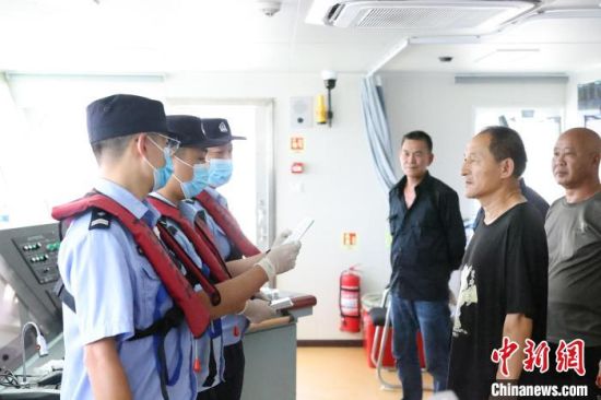 8月26日，宁德边检站移民管理警察对船员进行认证对照。张文奎 摄