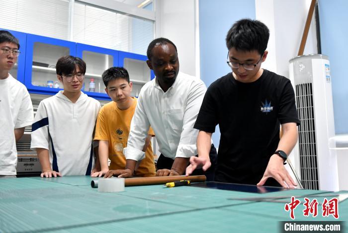 8月30日，南吉姆瓦(右二)在福州指导学生制备复合材料结构试样。　中新社记者 吕明 摄