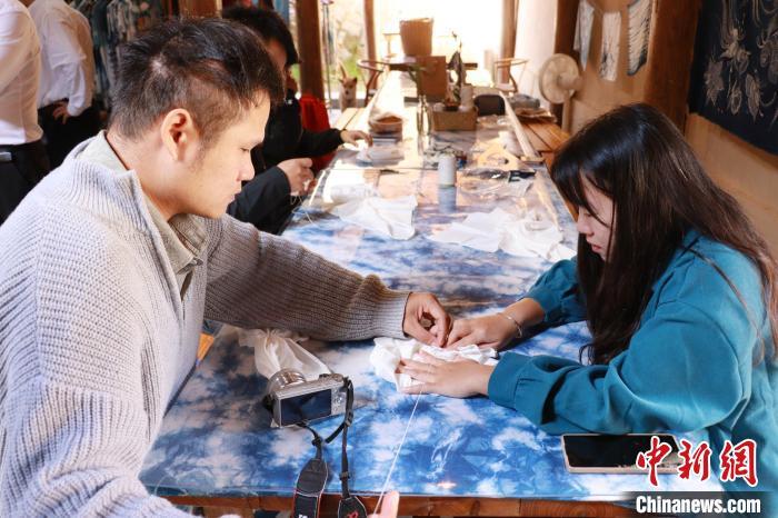 游客体验制作手织布。林榕生 摄