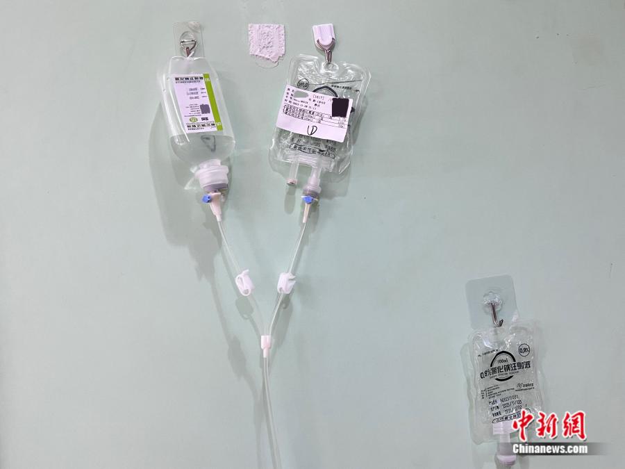 北京儿童医院门诊大楼，家长们在墙壁上贴上挂钩，用来悬挂输液袋。邵萌 摄