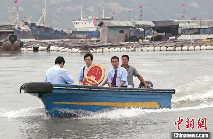 三都海上巡回法庭设立之初，法官们带着国徽、坐着快艇，到渔排上审理、调解案件。(资料图)蕉城区人民法院 供图