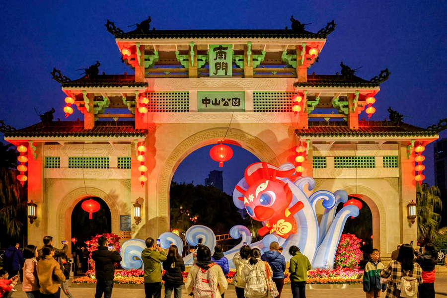 中山公园牌坊上悬挂着大红灯笼，“福瑞龙”踏浪造型布景引人注目。杨劲坚摄