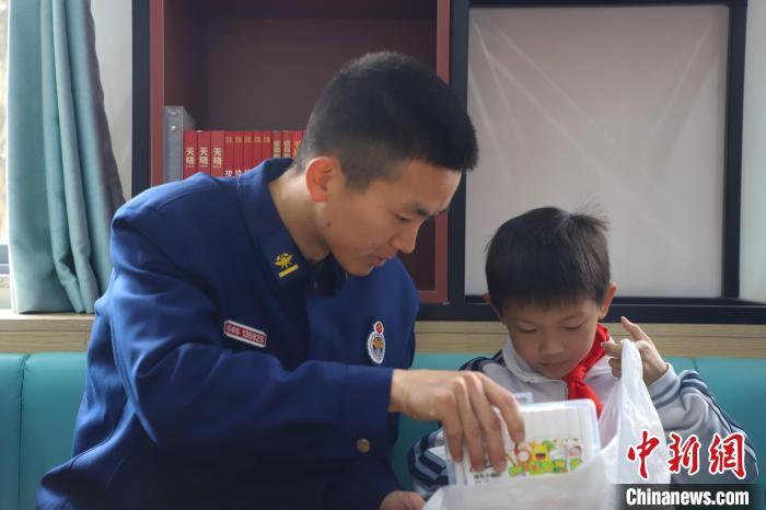 图为消防员赠送礼物给学生。李袁辉摄