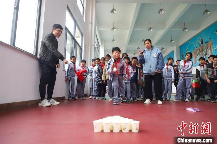 图为学生在进行纸杯投球游戏。　李袁辉 摄