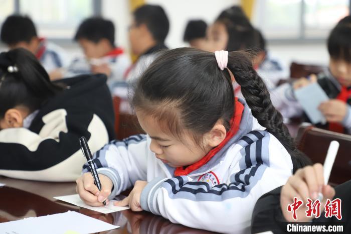 图为学生在贺卡上写祝福语。李袁辉摄