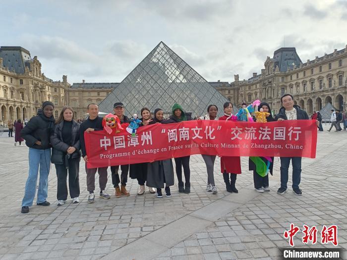 2月9日，漳州市布袋木偶传承保护中心演员在法国卢浮宫进行快闪表演后，与外国游客合影。　(漳州市布袋木偶传承保护中心 供图)
