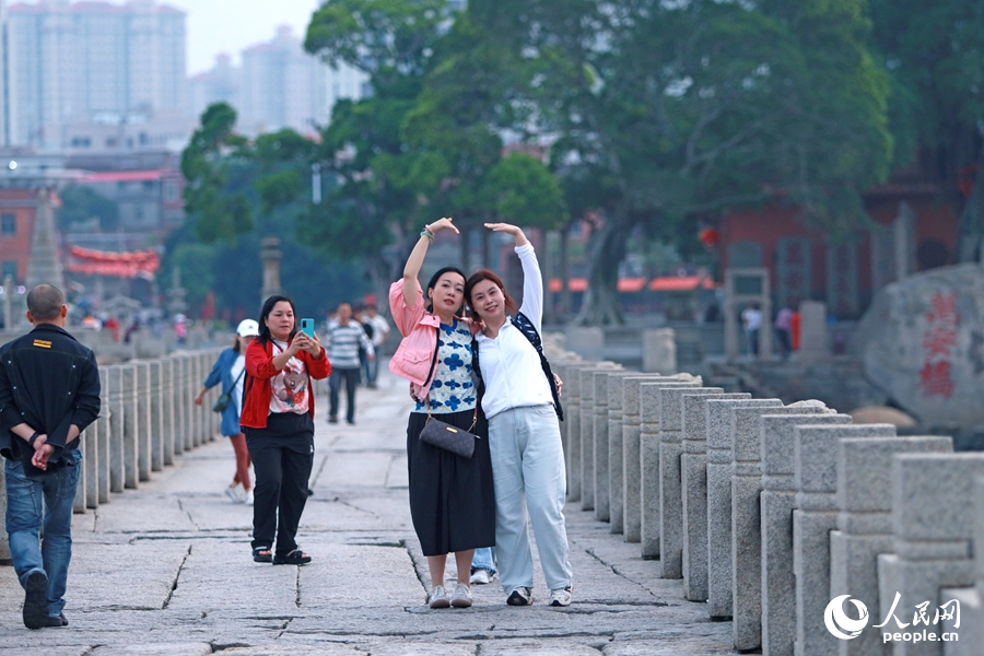 来自广东的游客在洛阳桥上打卡拍照。人民网 李昌乾摄