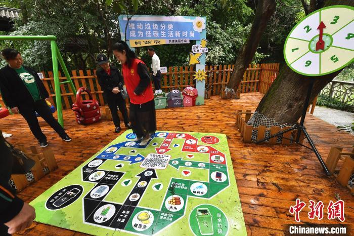 图为5月13日，迷宫式户外垃圾分类科普空间里的垃圾分类飞行棋游戏吸引参观者。　中新网记者 张斌 摄