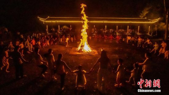 畲族村民与游客手拉手围着篝火载歌载舞。邱仰左摄