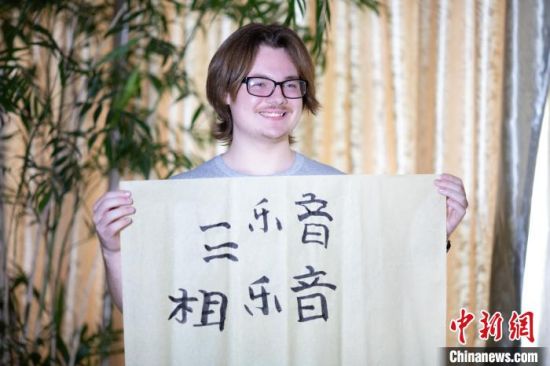美国中田纳西州立大学学生雅克布·扬用毛笔写下“音乐”两字。　中新社记者 李思源 摄