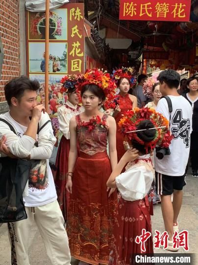 8月8日，头戴簪花的游客在蟳埔村游览。中新网记者商永摄