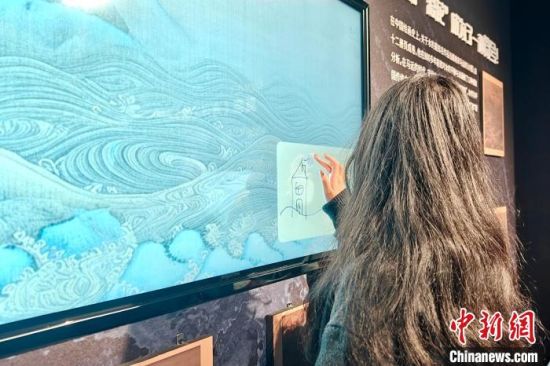2月4日，在“无限之海——沉浸式AI数字艺术展(福州站)”的第二部分——“文明之海”，福州市民林璟潼正在大屏上绘画。叶秋云 摄