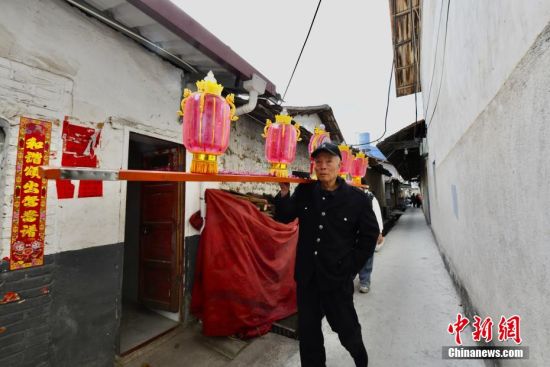 图为当地民众肩扛板凳龙圈灯前往宗祠接龙。中新社记者 王东明 摄