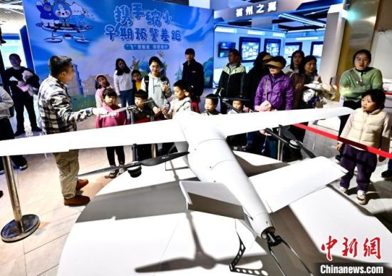 图为家长孩子参观无人机小镇。　郑帅 摄