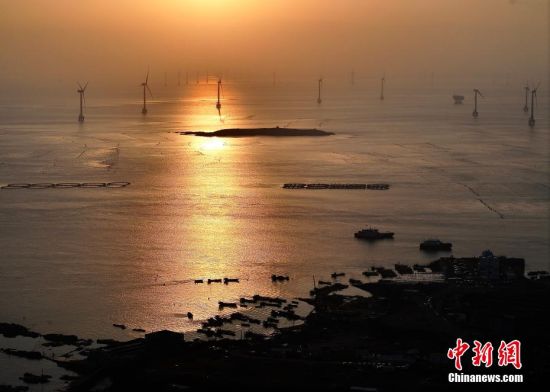 5月2日，福建福州福清市沙埔镇养殖海域，养殖网箱漂浮在海面上，海上风车依次排开，蔚为壮观。（无人机照片）中新社记者 张斌 摄