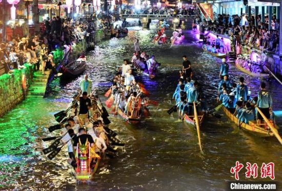 5月27日晚，三溪村村民在溪中夜竞龙舟。中新社记者 张斌 摄