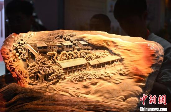 图为寿山石雕作品《龙腾盛世》吸引参观者。中新社记者 吕明 摄