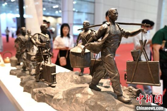 图为铜雕作品吸引参观者。中新社记者 吕明 摄