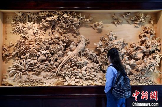 图为木雕作品吸引参观者。中新社记者 吕明 摄