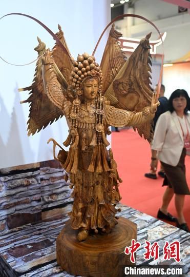 图为木雕作品《穆桂英》吸引参观者。中新社记者 吕明 摄