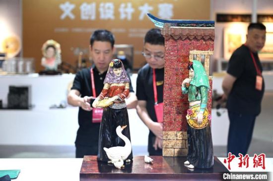 图为文创工艺品吸引参观者。中新社记者 吕明 摄