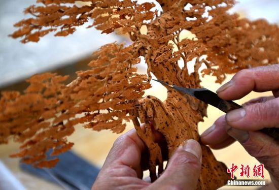 图为6月21日，陈国弦在福州的工作室制作软木画。软木画的原材料是从西班牙、葡萄牙和阿拉伯等地进口的栎树的木栓层软木，质地轻、松，富有弹性且纹理细润。中新社记者 吕明 摄