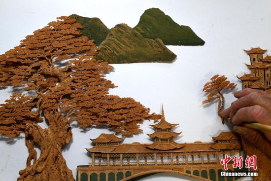 图为6月21日，陈国弦在福州的工作室进行软木画布景创作。中新社记者 吕明 摄