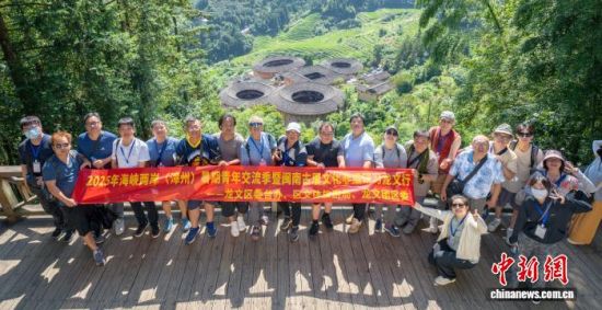图为一行人和福建漳州南靖土楼合影留念。福建省古厝文化研究会供图