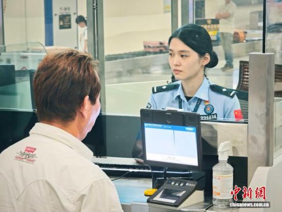 8月1日，福州机场边检站民警正在为旅客办理通关手续。　乔木 摄