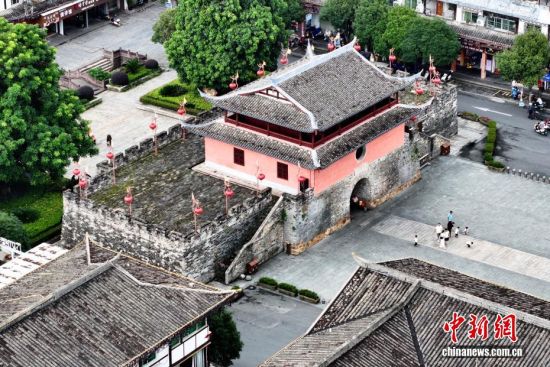 图为8月21日，游客在三元阁旁游览。三元阁原是唐代古城门，始建于唐大历年间，现已成为长汀古城的标志性建筑。（无人机照片）中新社记者 张斌 摄