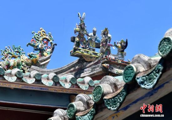 图为9月12日，东山关帝庙内拍摄的彩瓷剪贴雕。彩瓷剪贴雕是闽南和广东一带寺庙建筑中的一种地方传统手工技艺，选取颜色鲜艳的彩釉瓷碗瓷盘为材料，用钳子、锤子、砂轮等工具剪、敲、磨成形状大小不等的瓷片，用来贴雕人物、动物、花卉、山水，装饰建筑物的屋脊翘角、壁画，具有色彩鲜艳、造型生动等特点。中新社记者 张斌 摄