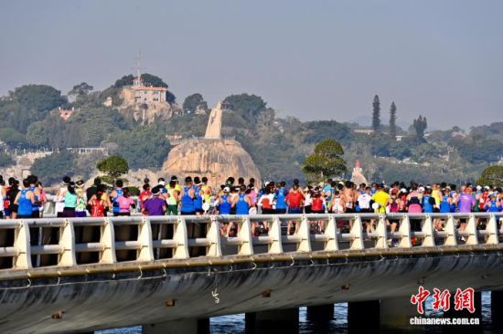 图为选手经过厦门著名景点郑成功雕塑。中新社记者 王东明 摄