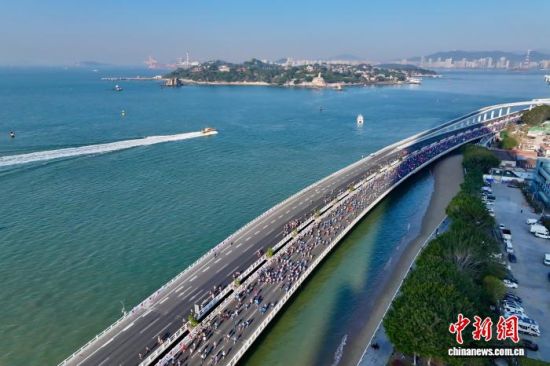 图为参赛选手在演武大桥赛段奔跑，远处是厦门著名景点鼓浪屿。(无人机照片)中新社记者 王东明 摄